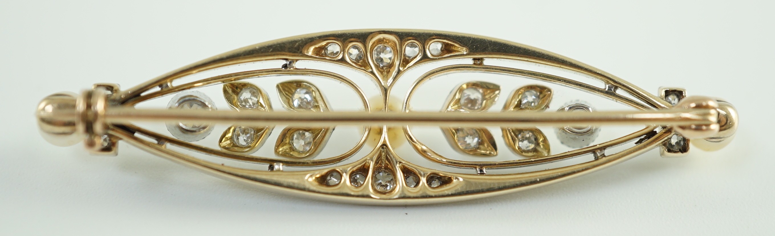 An early to mid 20th century gold and platinum, pearl and round cut millegrain set diamond cluster oval brooch